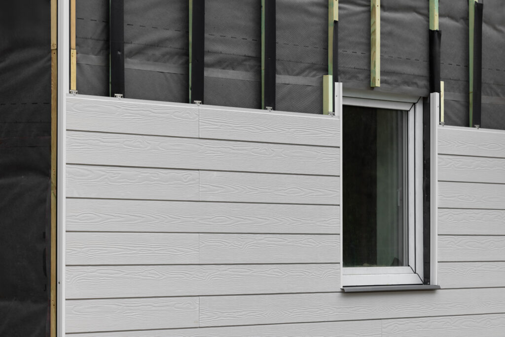Wood texture composite cladding installation on house facade.